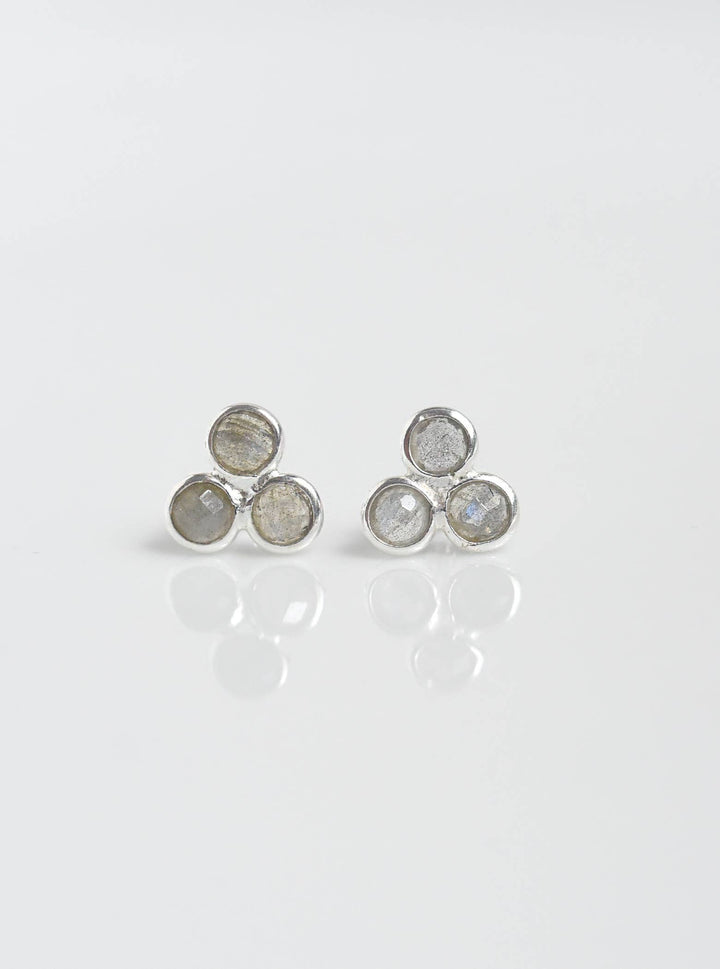 a pair of silver and white earrings on a white surface