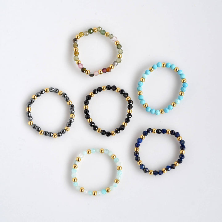 four bracelets with beads and beads on a white surface