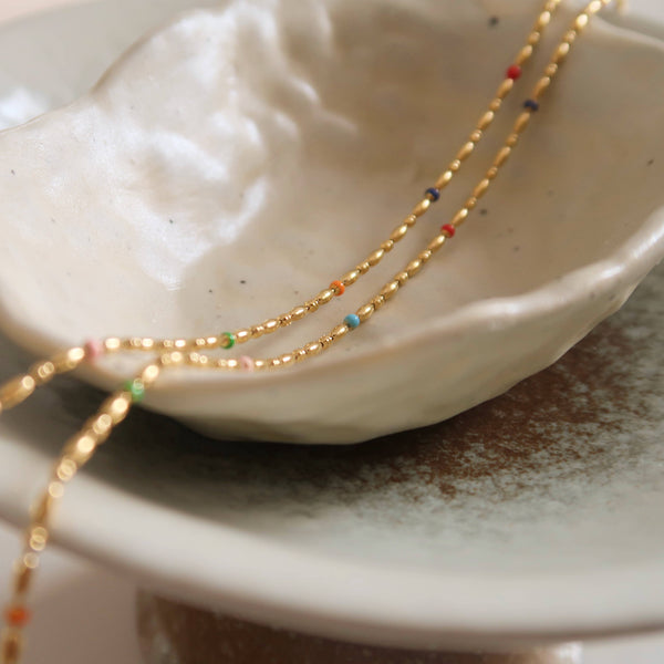 a close up of a plate with a beaded necklace on it