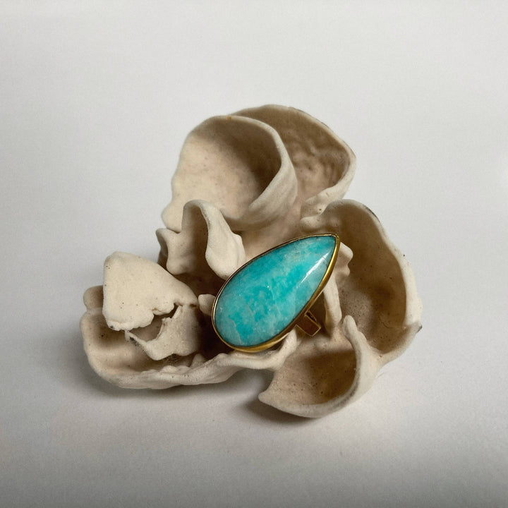 a turquoise ring sitting on top of an egg shell