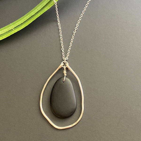 a necklace with a black stone hanging from it