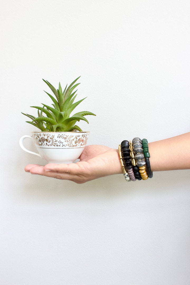 a person holding a cup with a plant in it