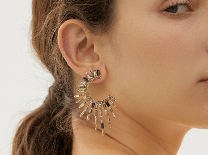 a close up of a person wearing a pair of earrings