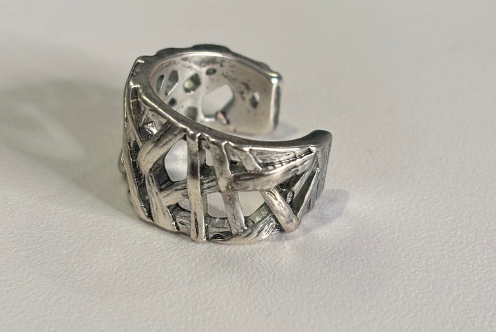 a silver ring sitting on top of a white table