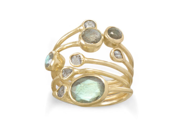 a gold ring with green and white stones