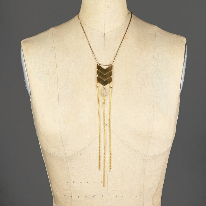 a white mannequin with a gold necklace on it