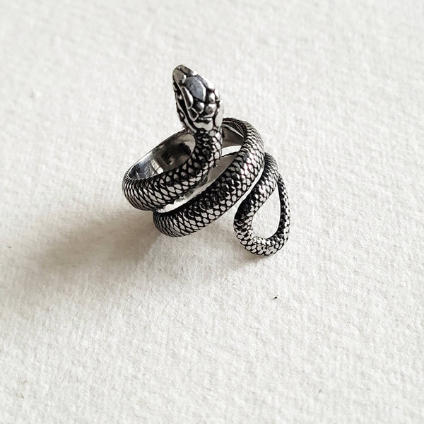 a snake ring sitting on top of a white surface