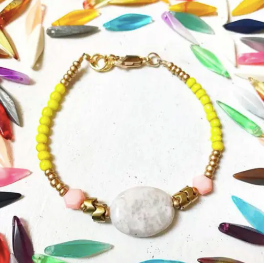 a bracelet with a white bead and a yellow bead