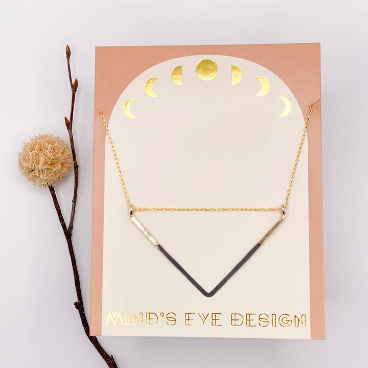 a card with a necklace and a flower on it