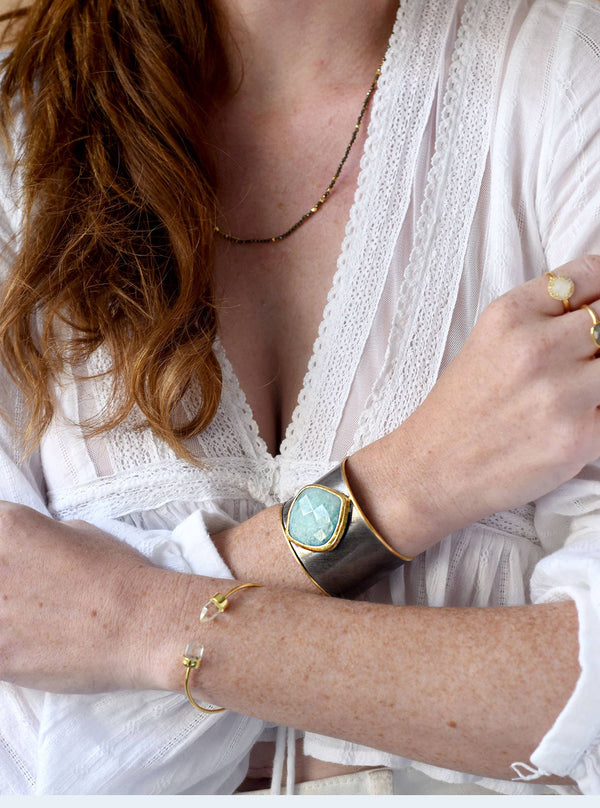 a woman wearing a white shirt and a gold bracelet