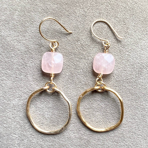 a pair of gold earrings with pink stones