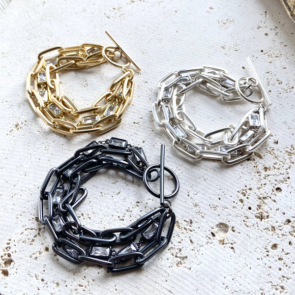 three different types of chain bracelets on a table