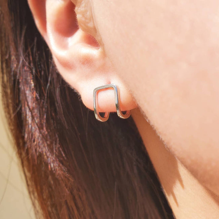 a close up of a person wearing a pair of earrings