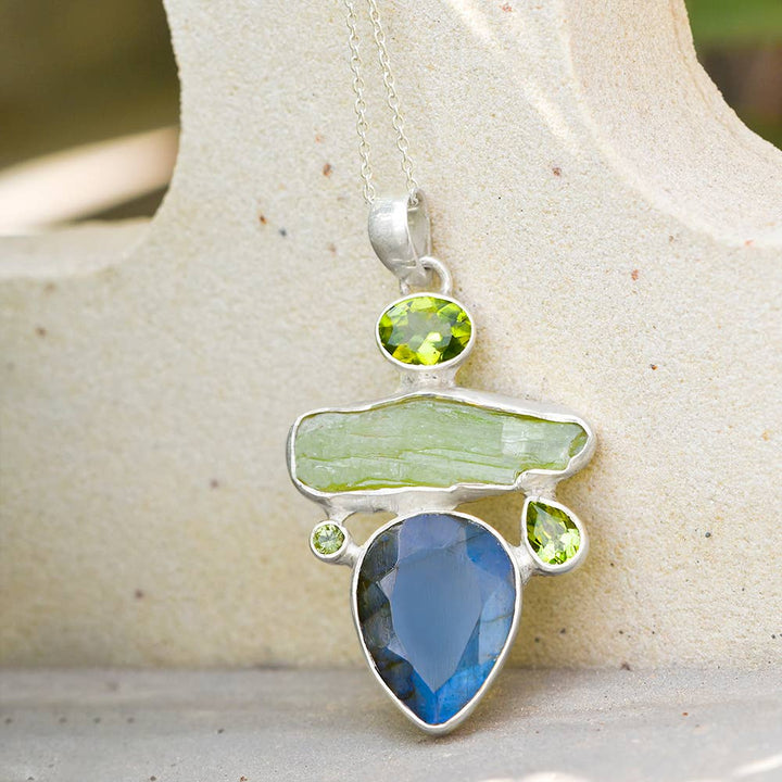 a green and blue pendant on a silver chain