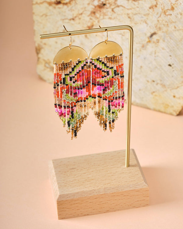 a pair of earrings on a wooden stand