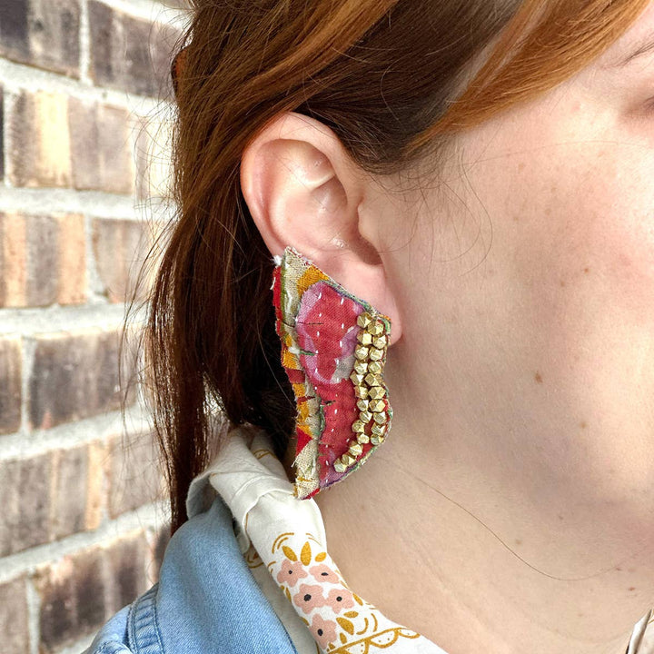 a close up of a person wearing a pair of earrings