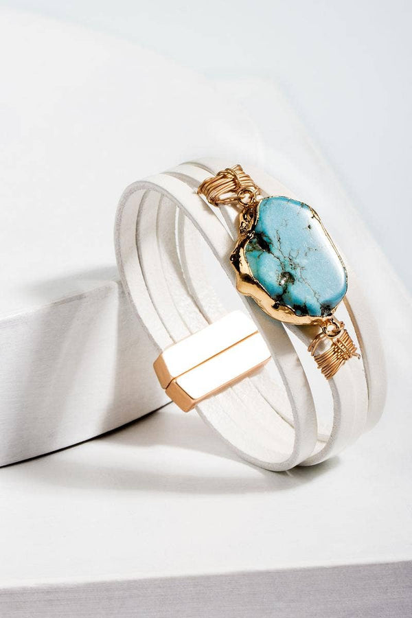 a white bracelet with a turquoise stone on it